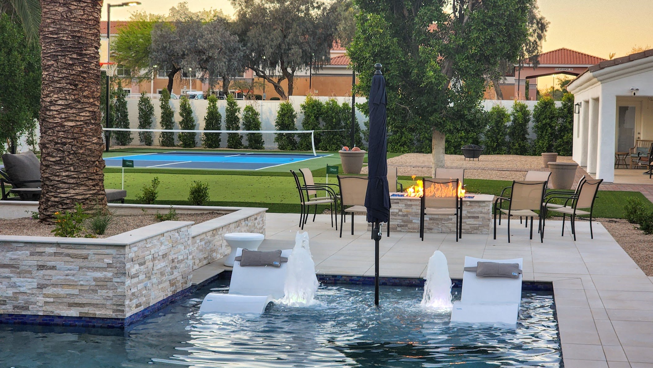 Pool with bubblers, fireplace and pickleball court